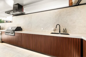Custom outdoor kitchen with Spotted Gum AliBattens cabinetry and 60mm Corian Whisper benchtops