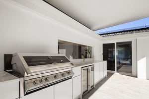Two-part outdoor kitchen with built-in BBQ and outdoor fridges