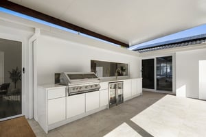 Two-part outdoor kitchen with built-in BBQ and outdoor fridges